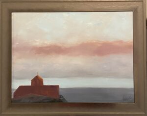 Painting of St Nicholas Chapel at sunset by Henry Leck, featuring a silhouette of the chapel against a soft pink and blue sky, framed in brown.