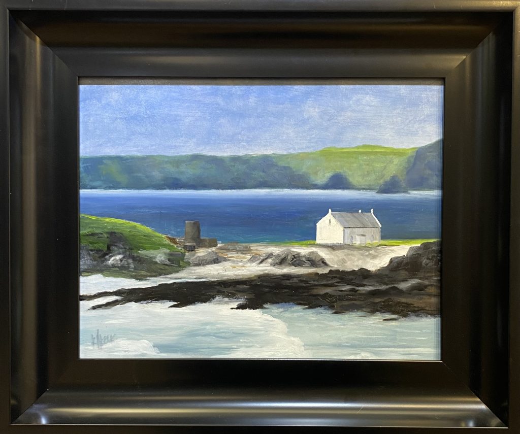 Framed oil painting titled 'Solitary' by Henry Leck, depicting a peaceful coastal scene with a single white cottage overlooking a blue bay and lush green hills.