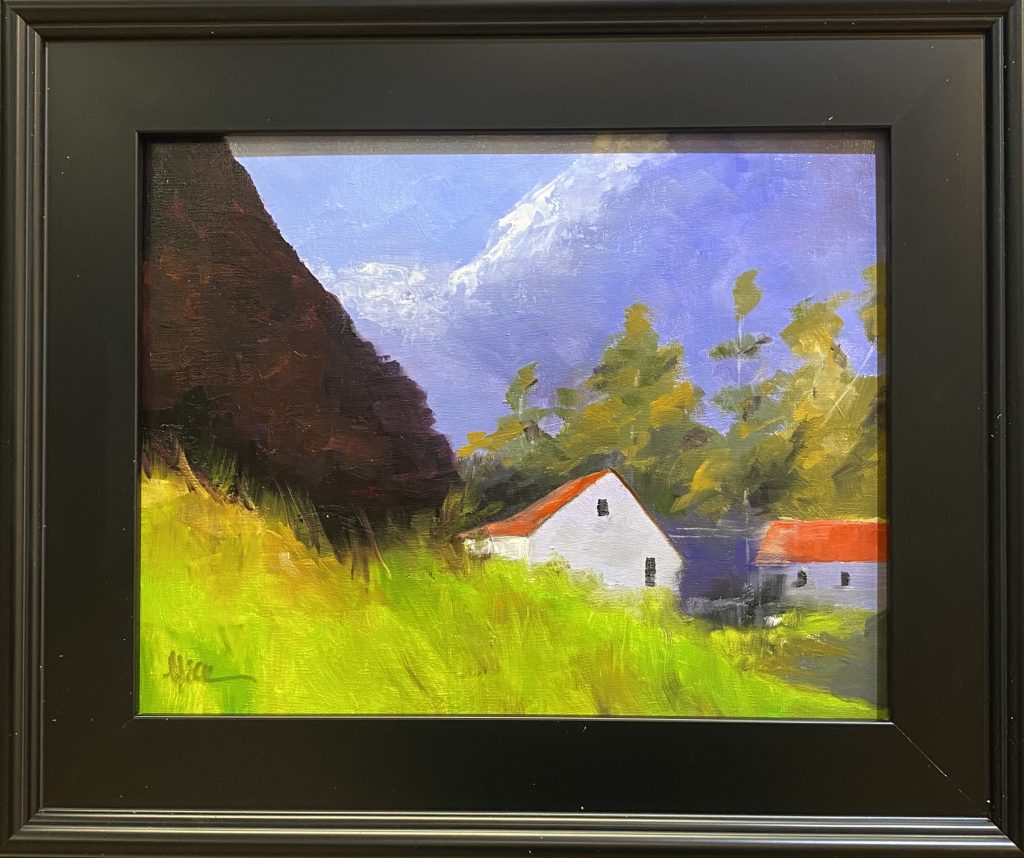 Framed oil painting titled 'Nestled Farm' by Henry Leck, depicting a charming countryside farm with white buildings and red roofs set against lush greenery and a towering mountain backdrop.