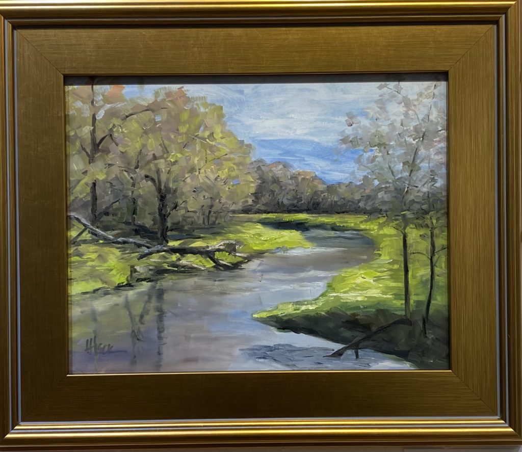 Framed oil painting titled 'Lazy Creek' by Henry Leck, depicting a peaceful meandering creek surrounded by lush greenery and soft sunlight filtering through the trees.