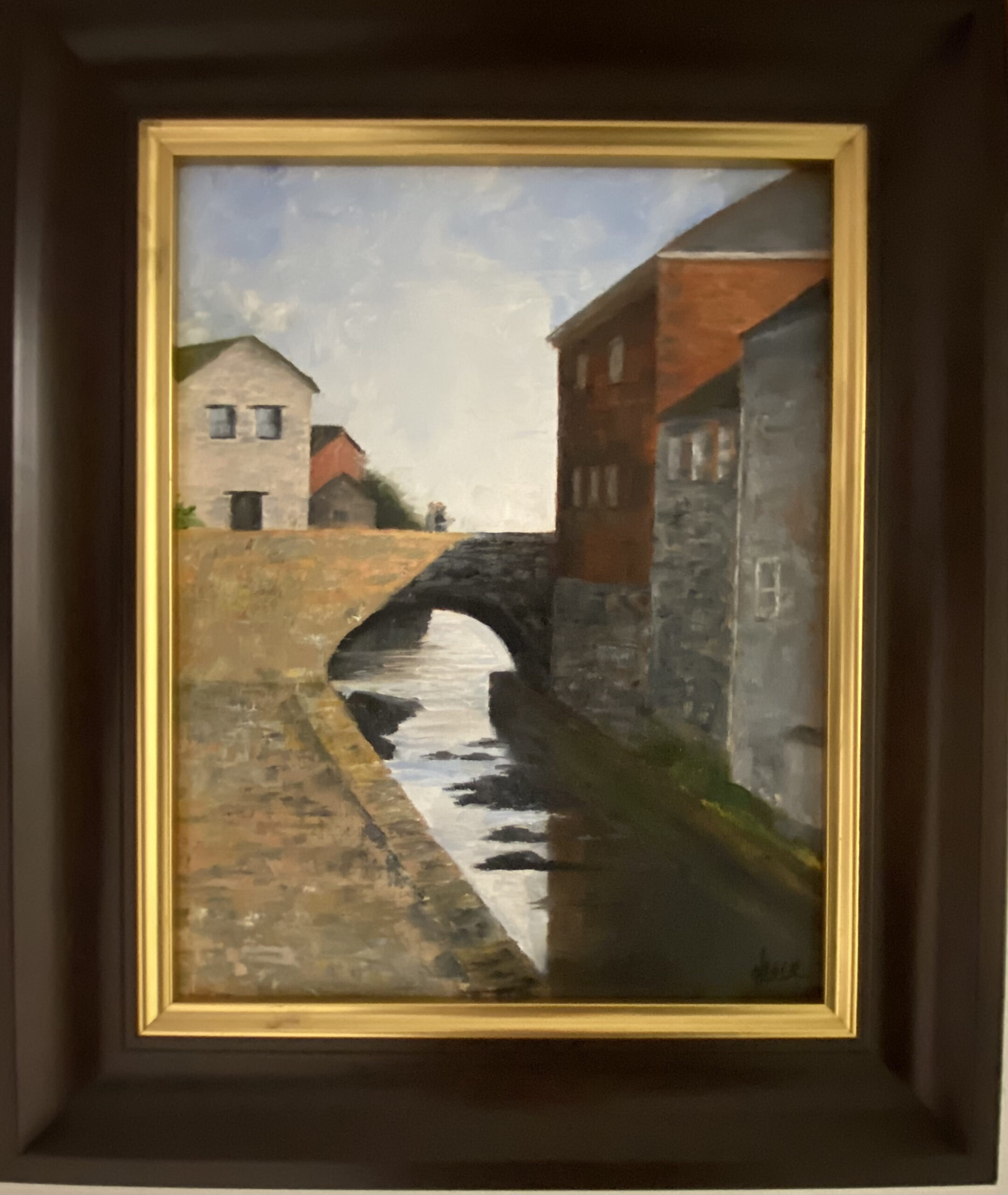 Early morning light bathes a stone bridge in a quaint town in this Henry Leck painting.